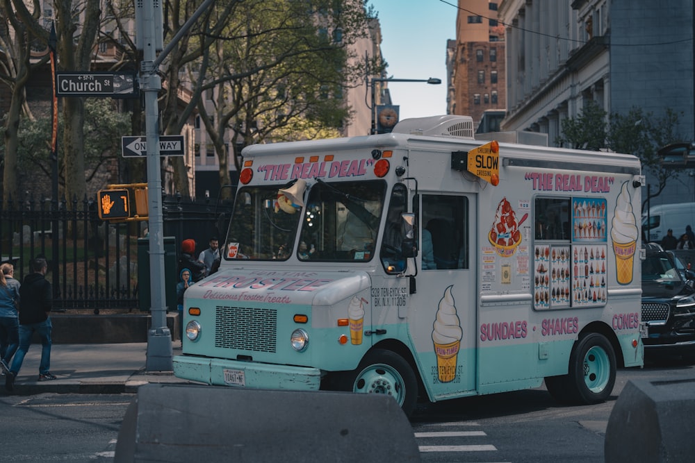 an ice cream truck driving down a city street