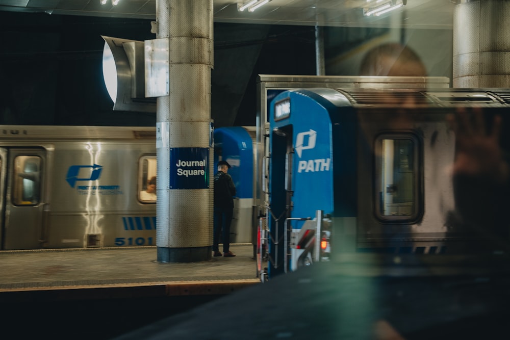 a person standing next to a train at a train station