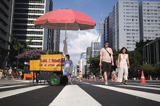 a man pushing a cart down a city street