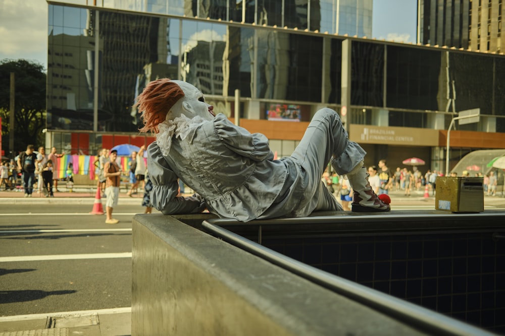 a person laying on a ledge in the middle of a city