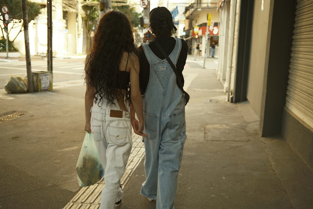 um casal de pessoas andando por uma rua