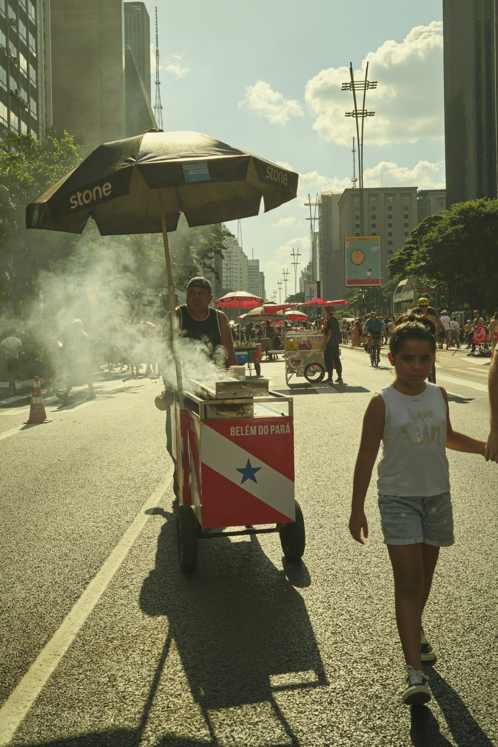 a woman walking down a street with a cart on wheels