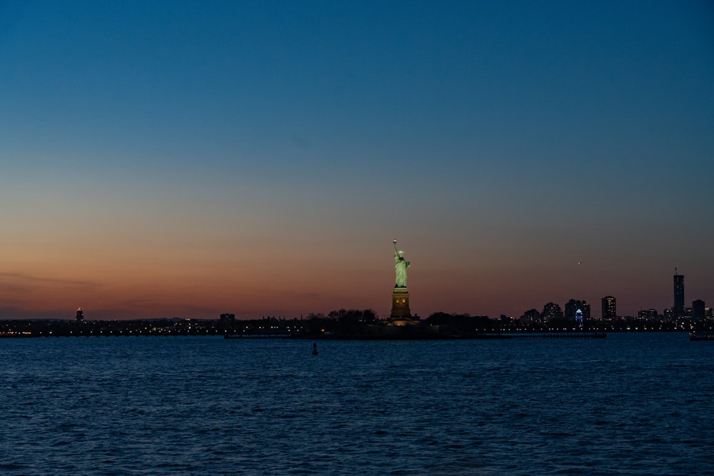 a large body of water with a statue of liberty in the background