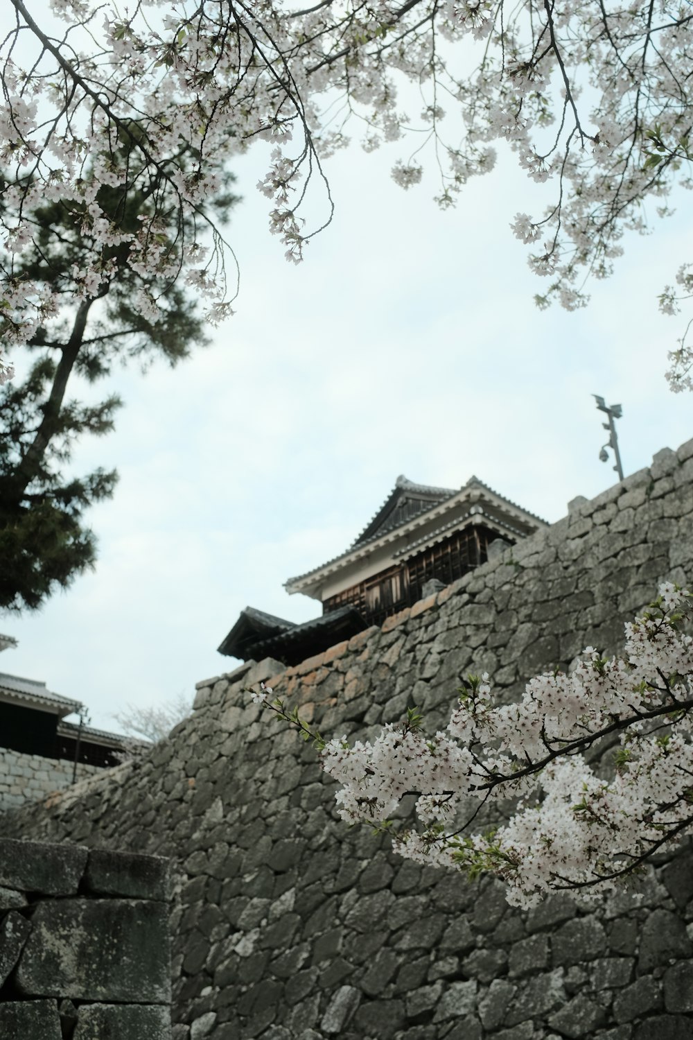 a stone wall with a building in the background