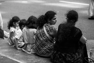a group of people sitting on the side of a road