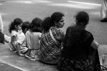 a group of people sitting on the side of a road