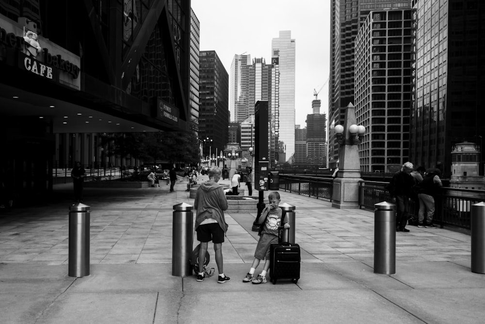 a black and white photo of a couple of people with luggage