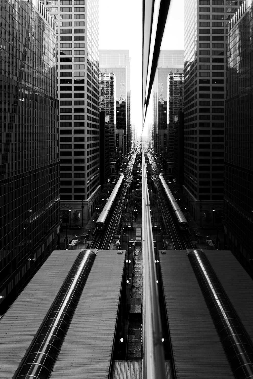 a black and white photo of a train track in a city