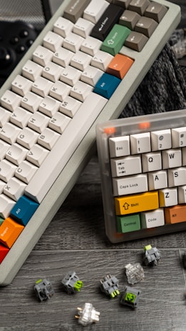 a couple of keyboards sitting on top of a wooden table