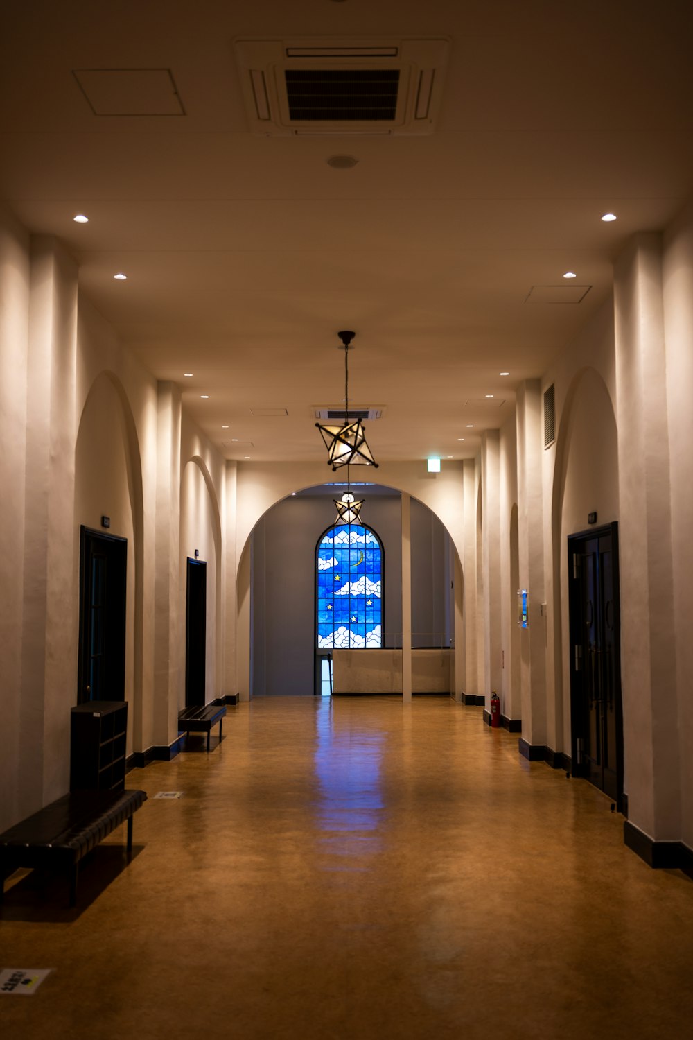 a long hallway with a chandelier hanging from the ceiling