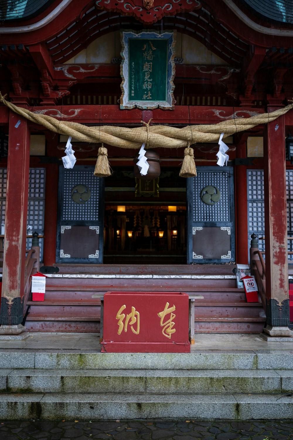 a red building with bells hanging from it's roof