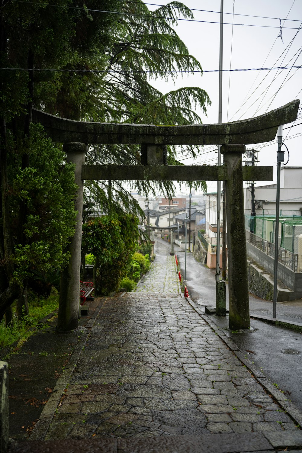 a street with a stone walkway and a wooden arch