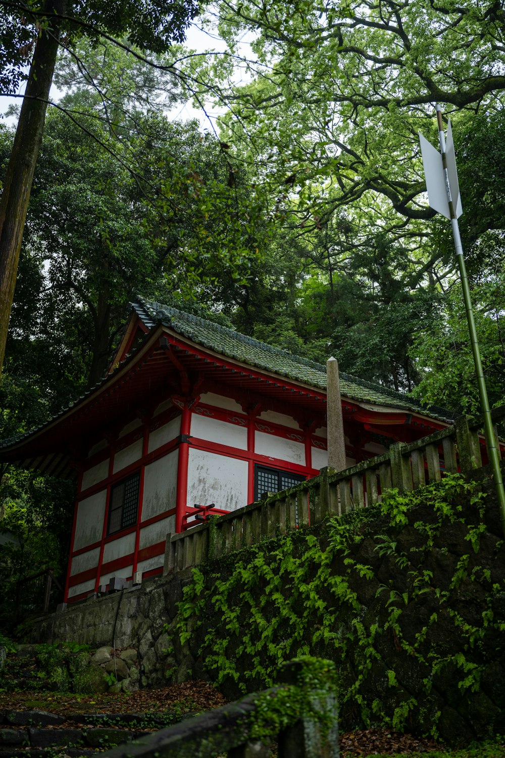 a small red and white building in the woods