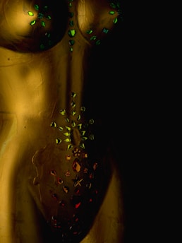 a close up of a gold colored object with green lights