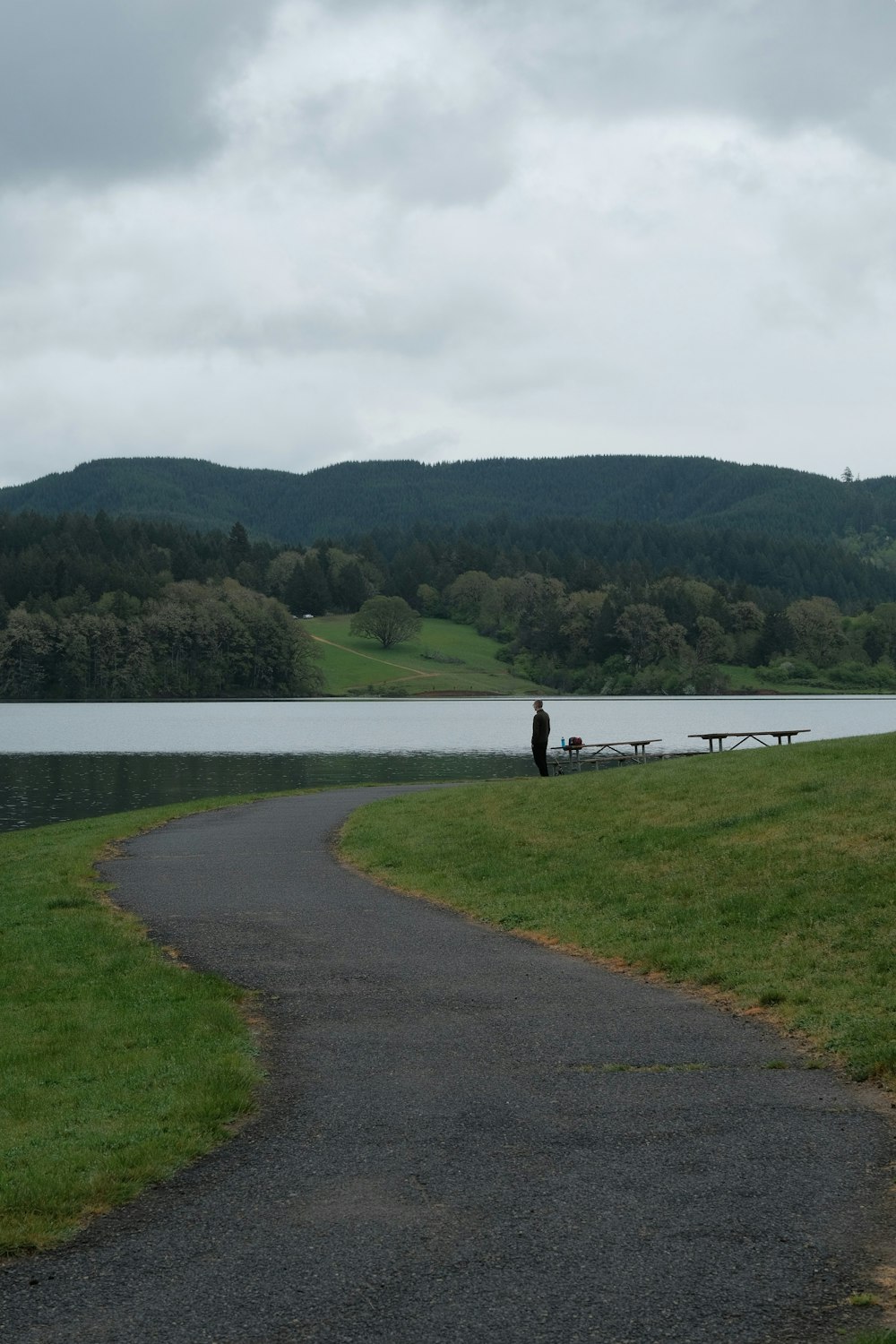 a person sitting on a bench near a body of water