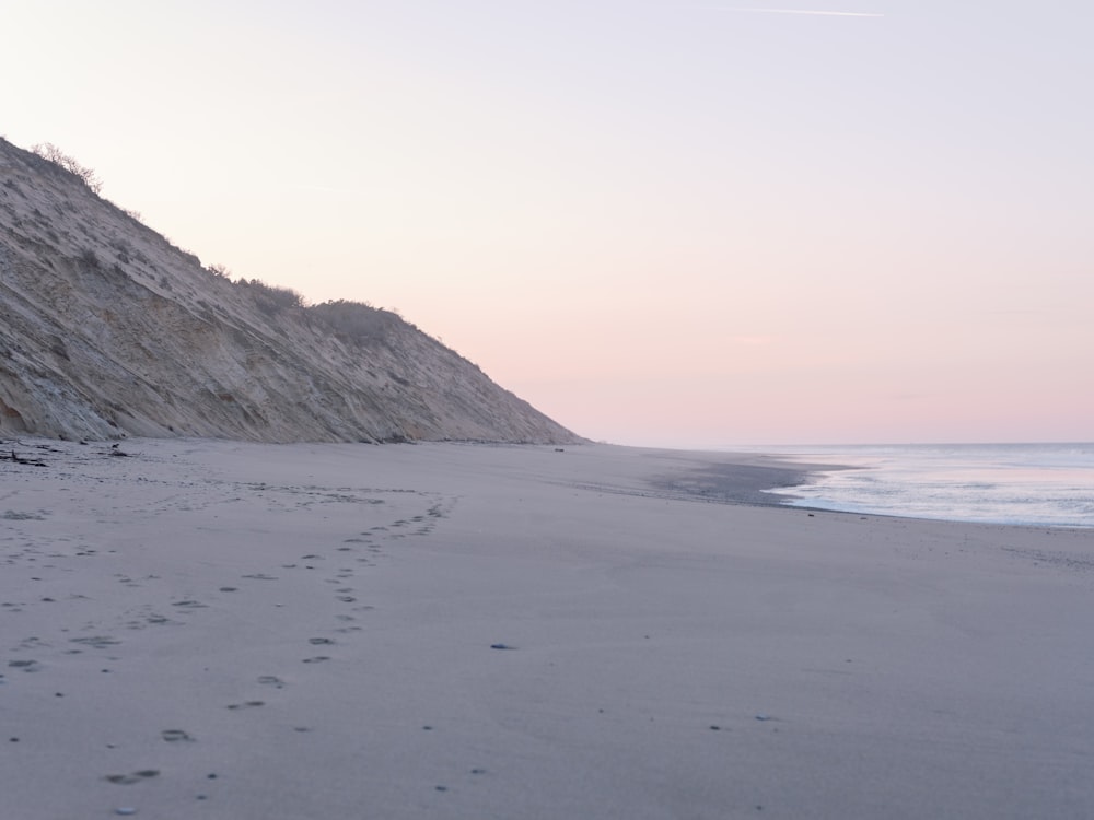 a sandy beach with footprints in the sand