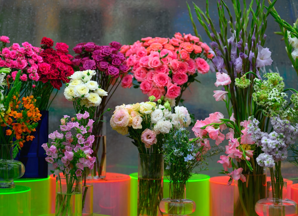 a group of vases filled with different colored flowers