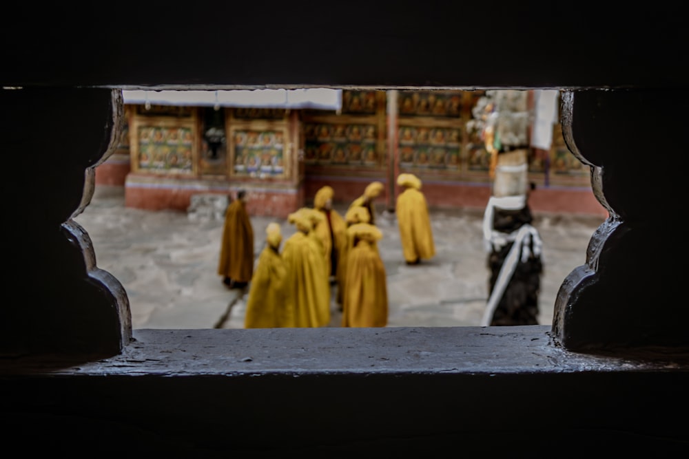 a group of people in yellow robes walking down a street