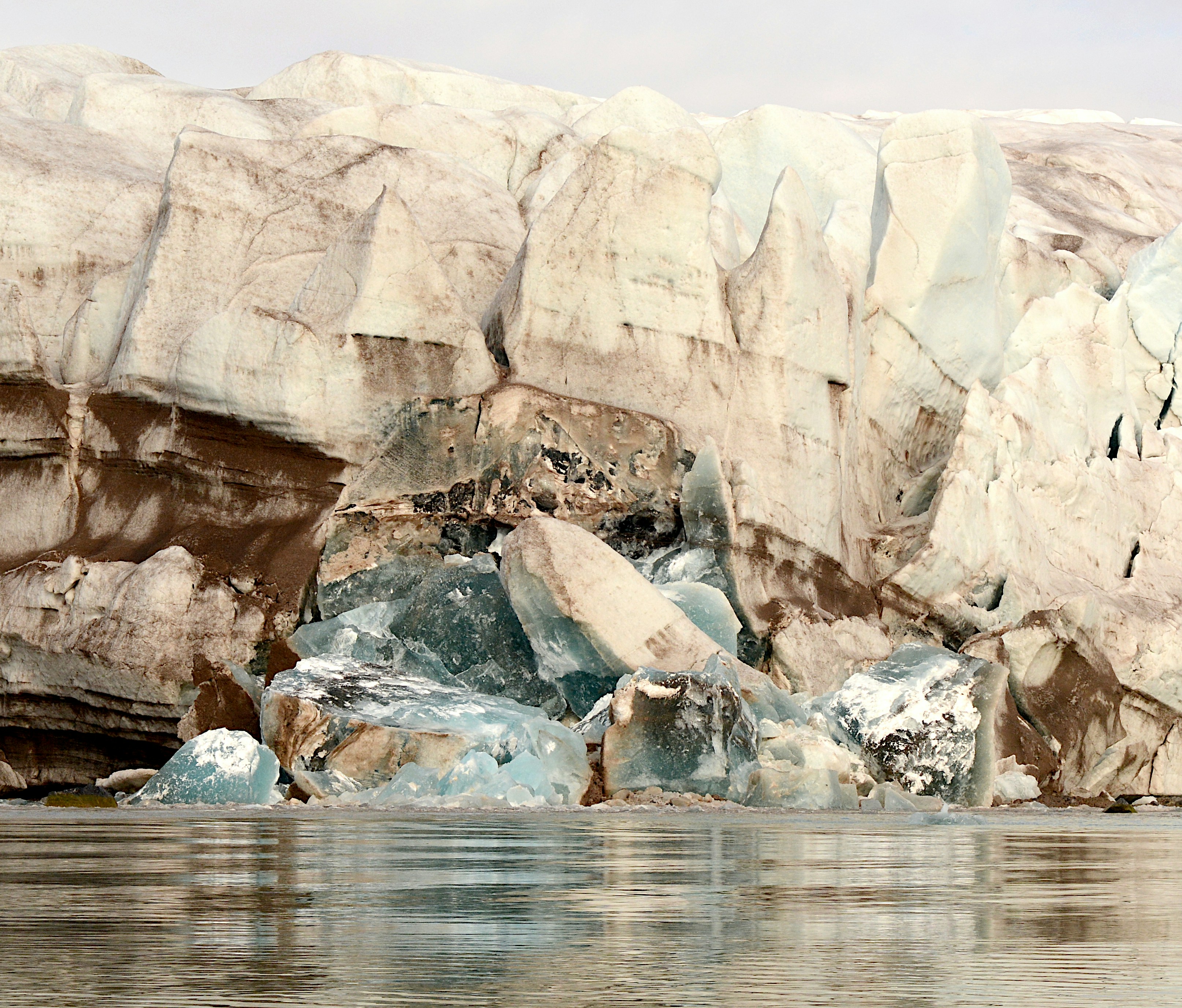 a group of large rocks sitting next to a body of water, 