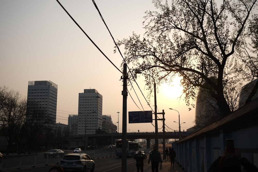 a group of people walking down a street next to tall buildings