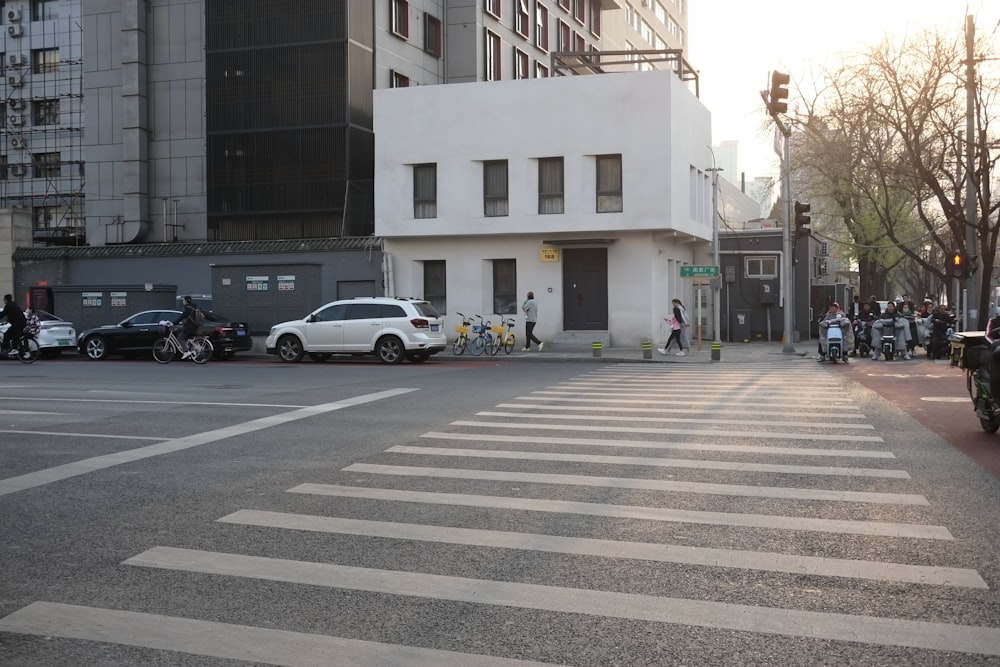 a city street with cars and motorcycles parked on the side of the road