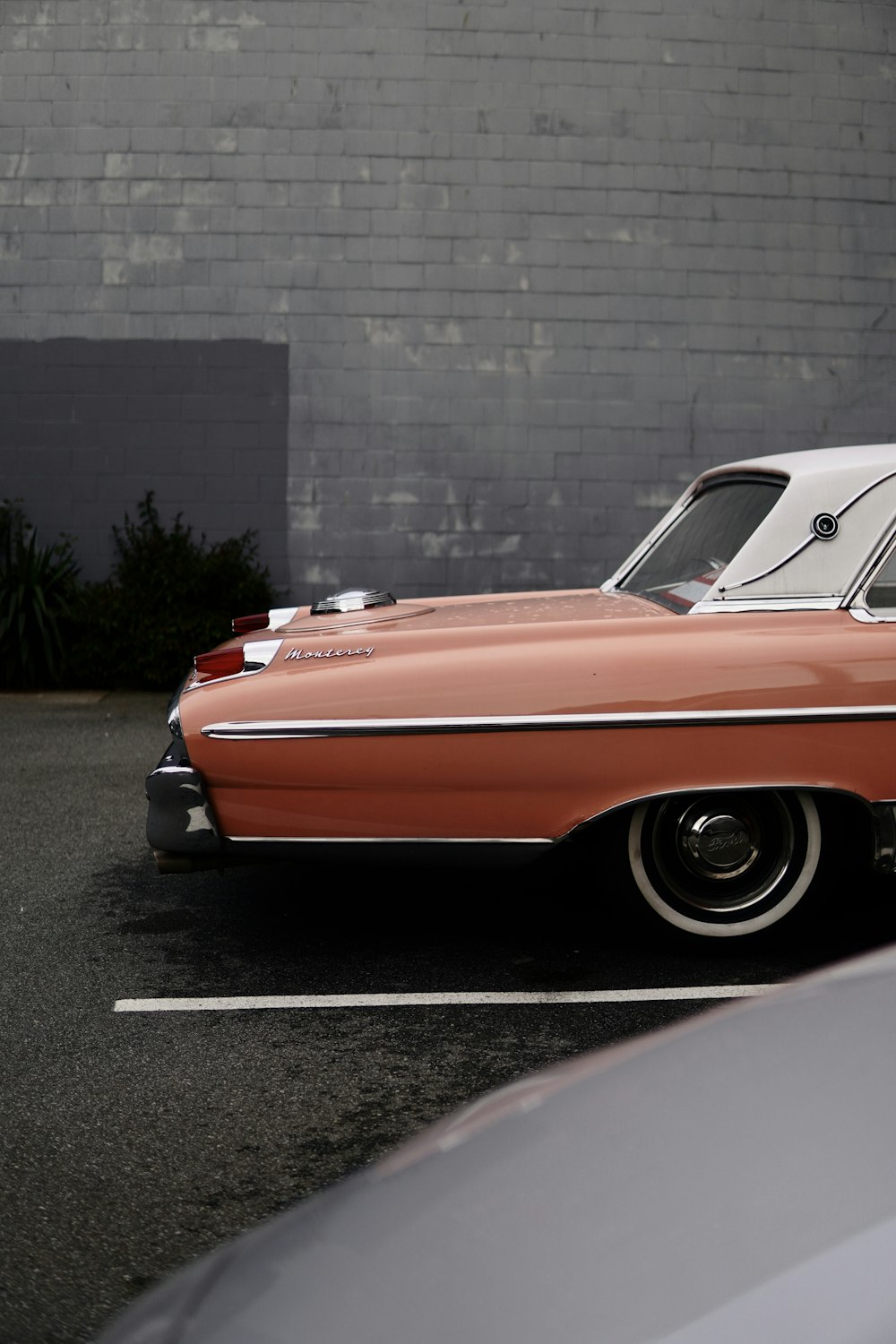 an orange and white car parked in a parking lot