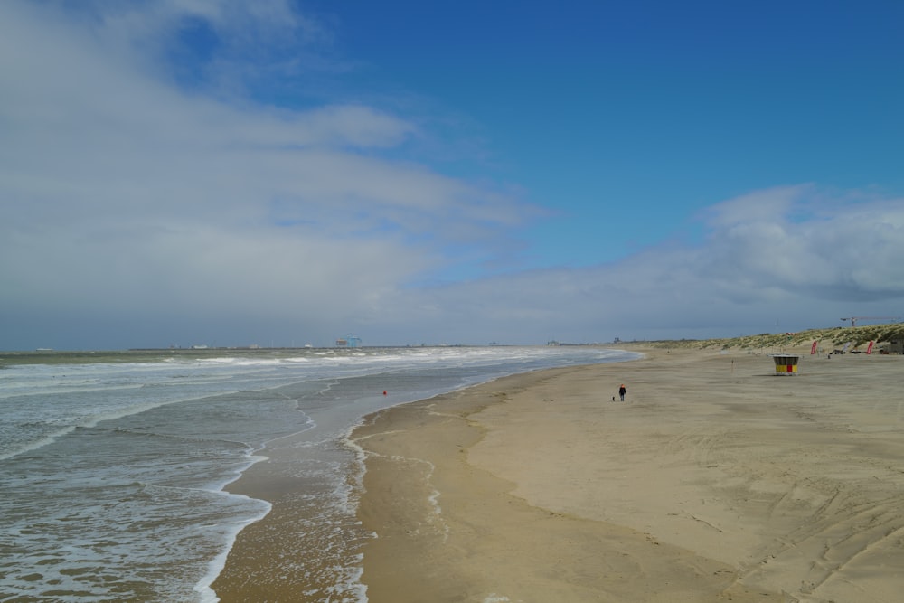 a person walking along a beach next to the ocean