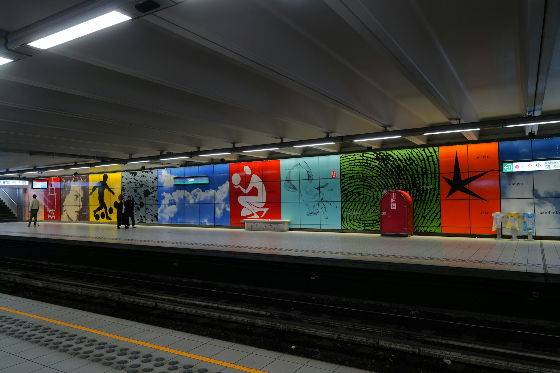 a train station with people standing on the platform