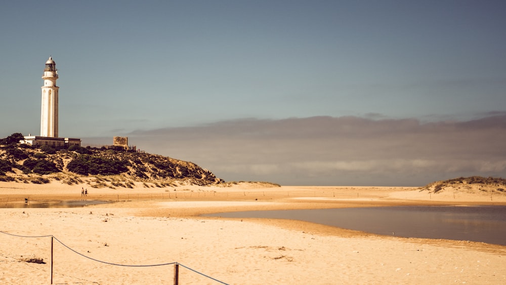 a light house sitting on top of a sandy beach
