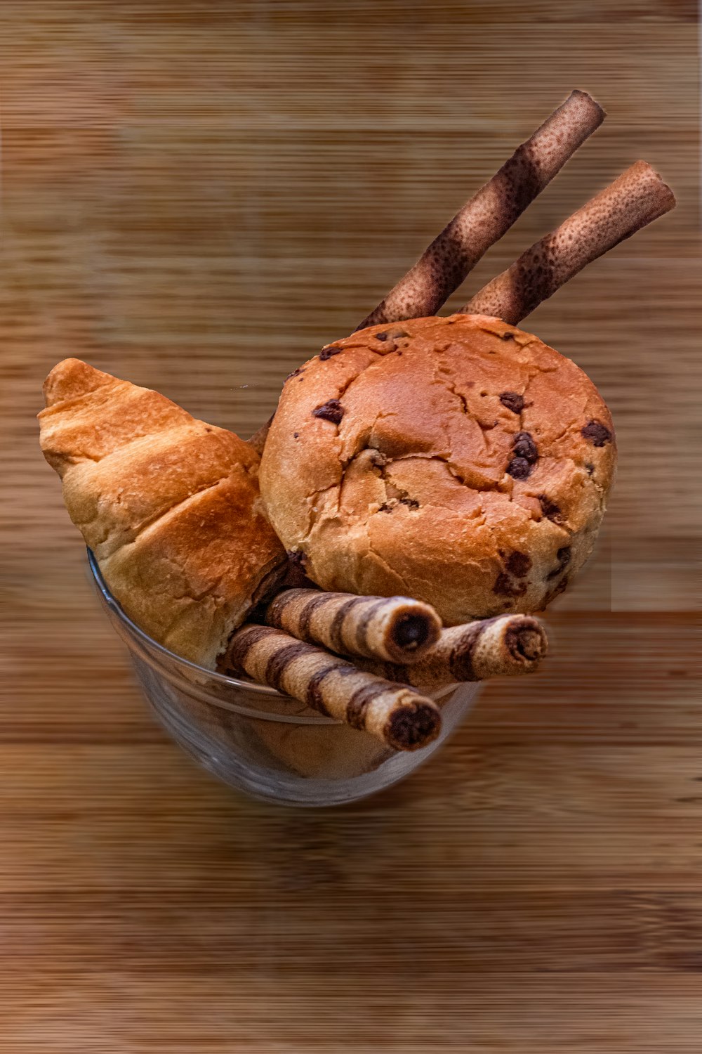 a loaf of bread sitting in a bowl with cinnamon sticks sticking out of it
