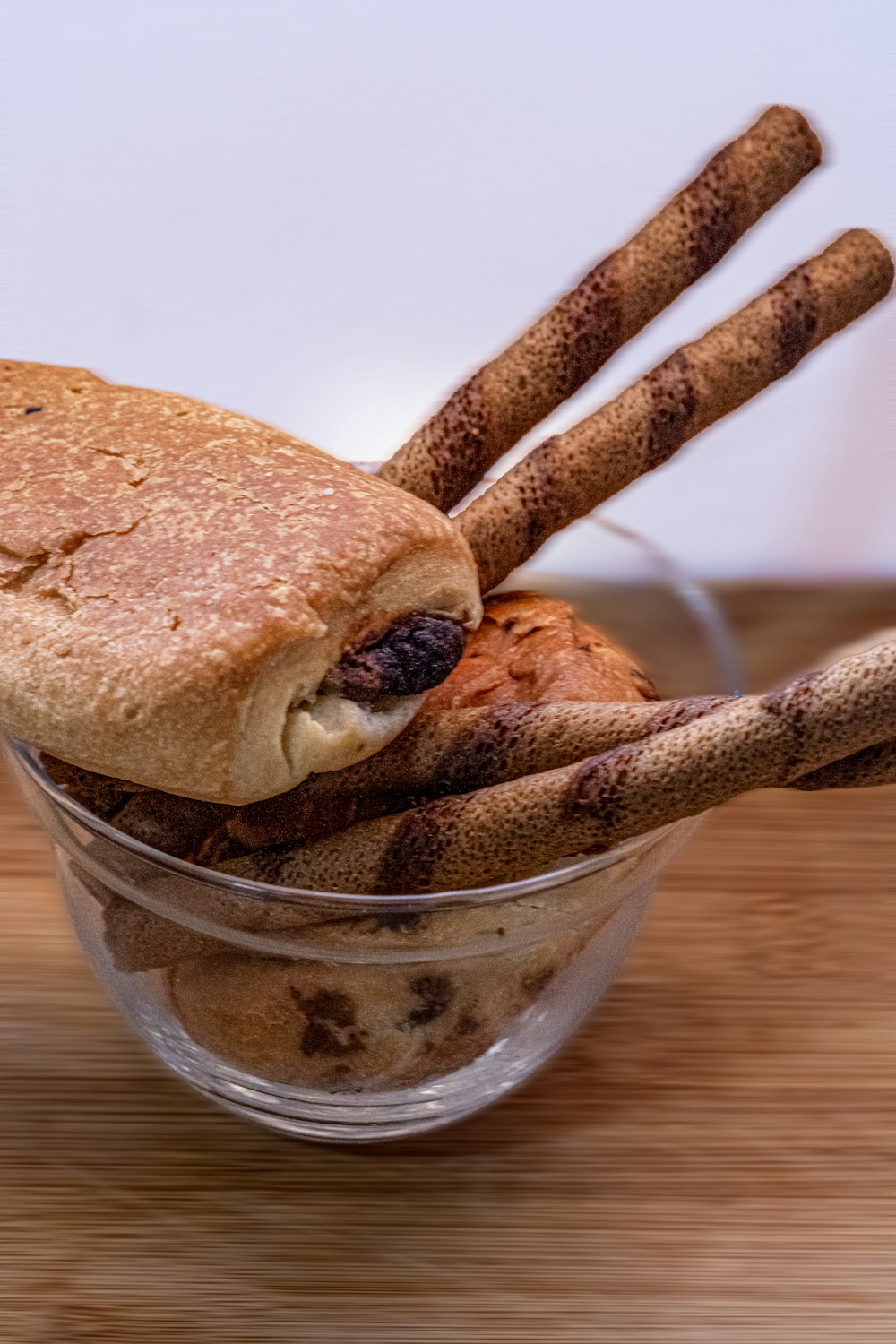 a sandwich in a glass bowl with cinnamon sticks sticking out of it