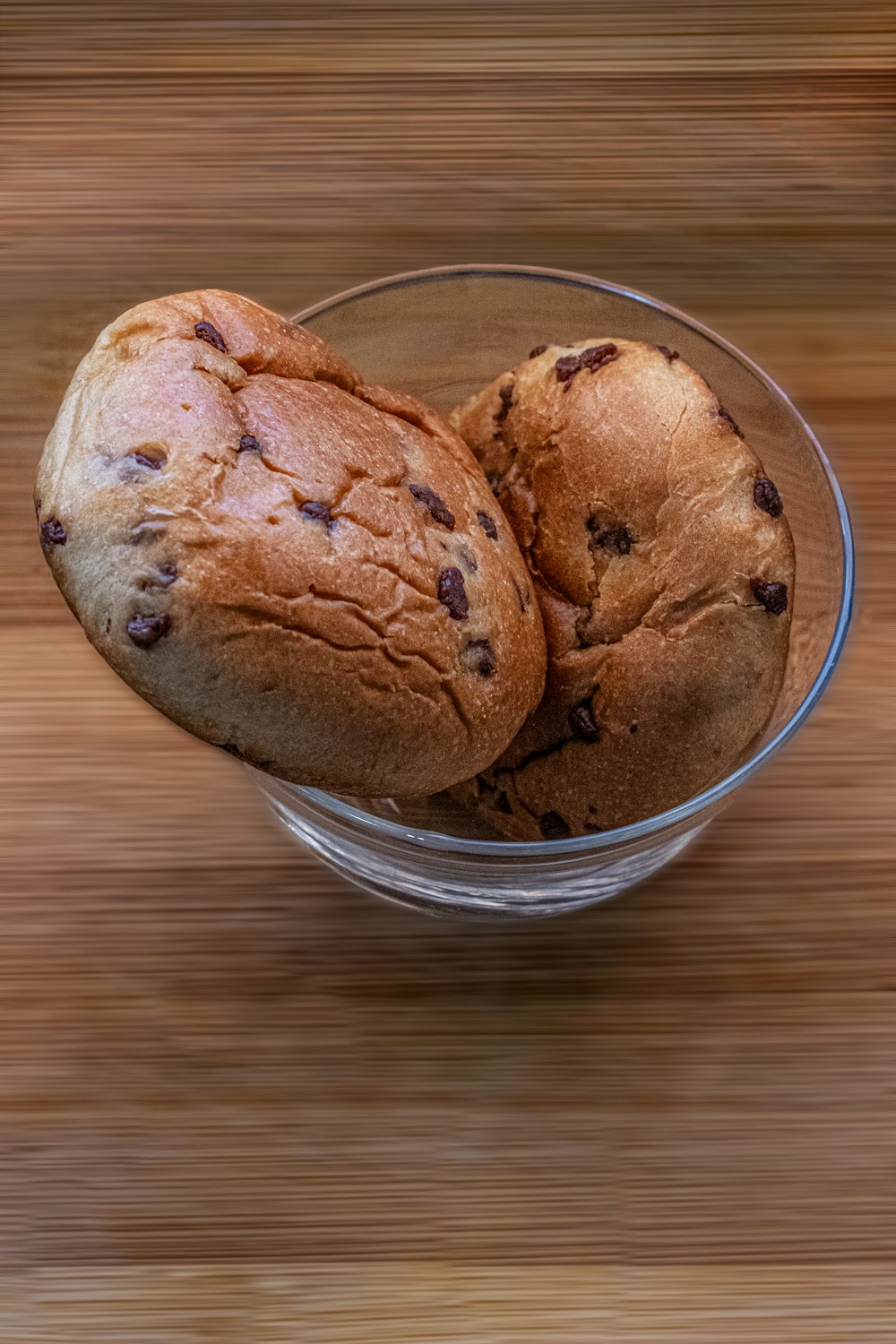two chocolate chip muffins in a glass bowl