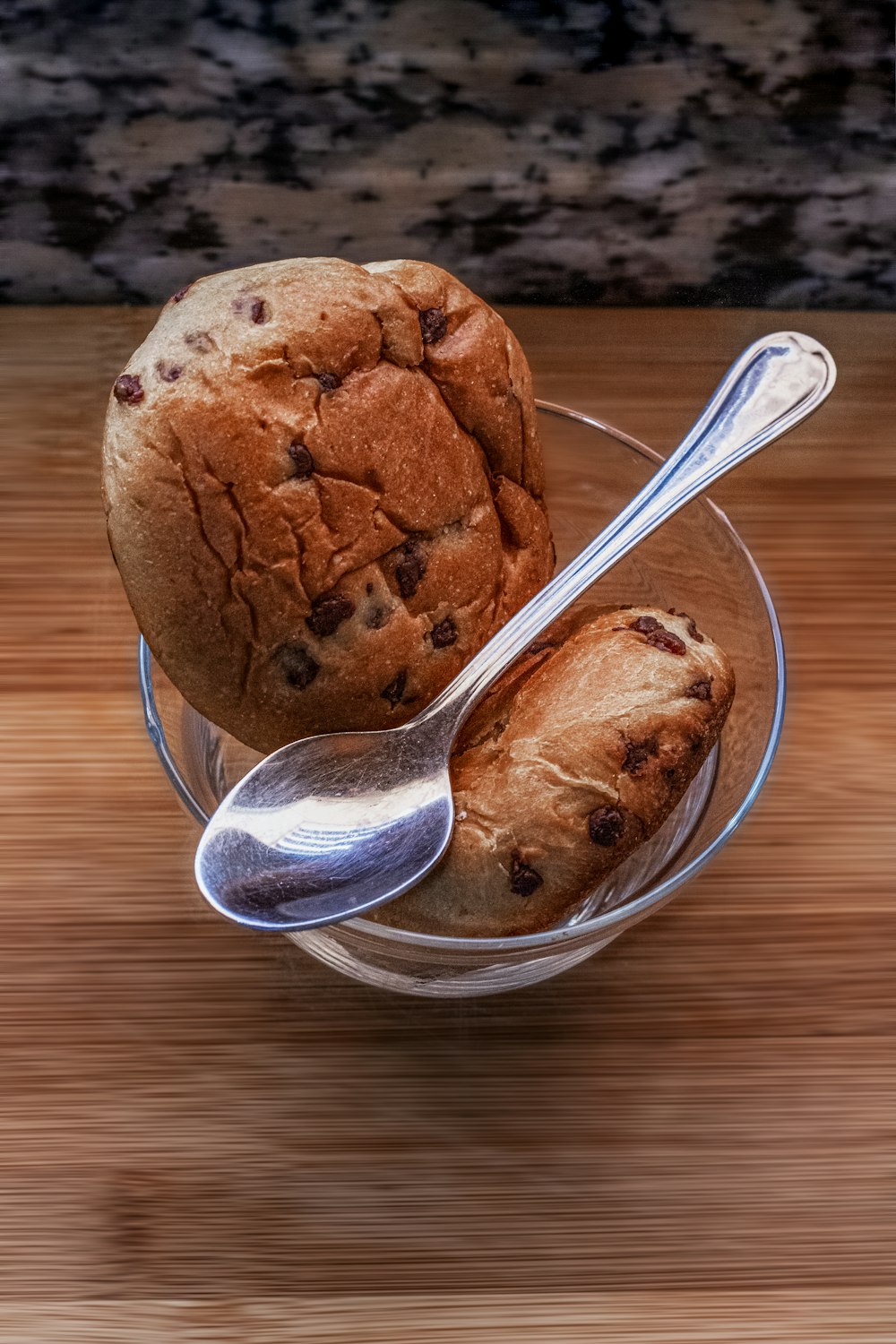 a bowl of cookies and a spoon on a table