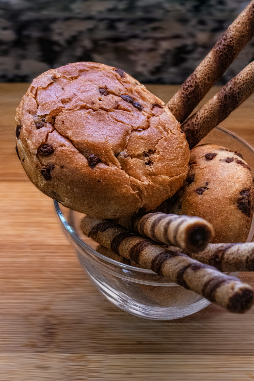 a bowl filled with cookies and sticks on top of a wooden table