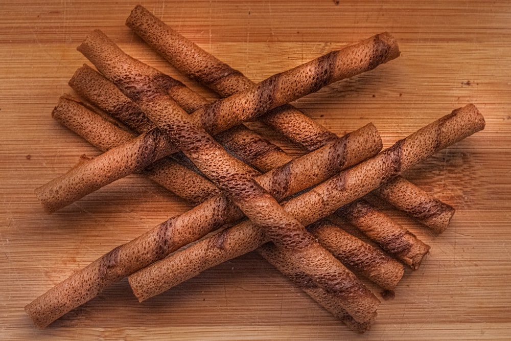a pile of cinnamon sticks sitting on top of a wooden table