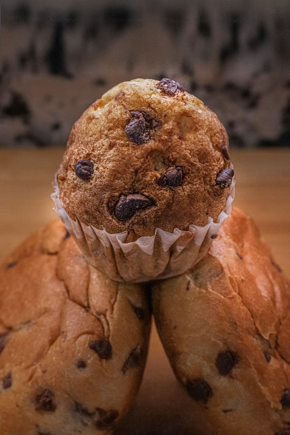 three chocolate chip muffins stacked on top of each other