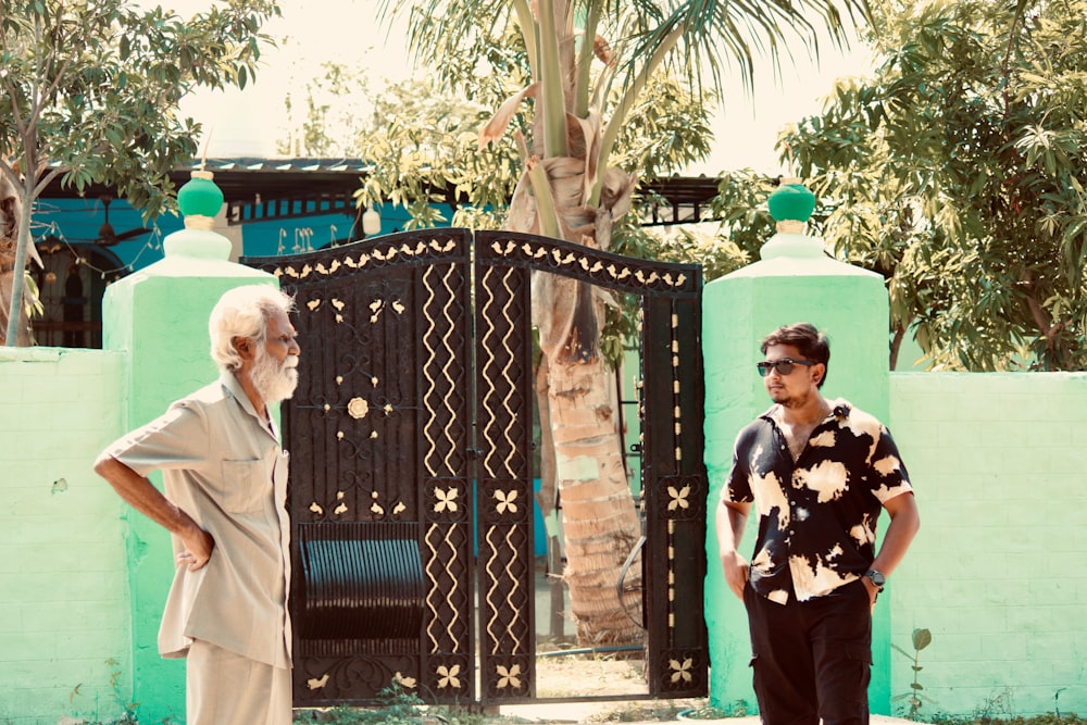two men standing in front of a gate