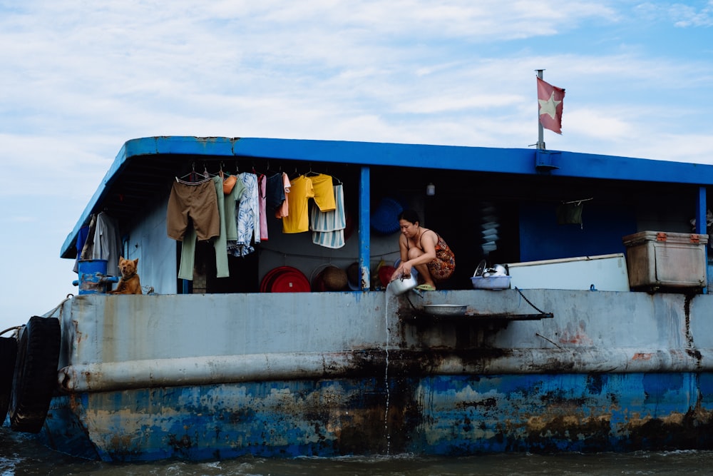 a man washes his clothes on the back of a boat