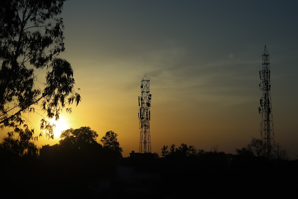 the sun is setting behind a radio tower