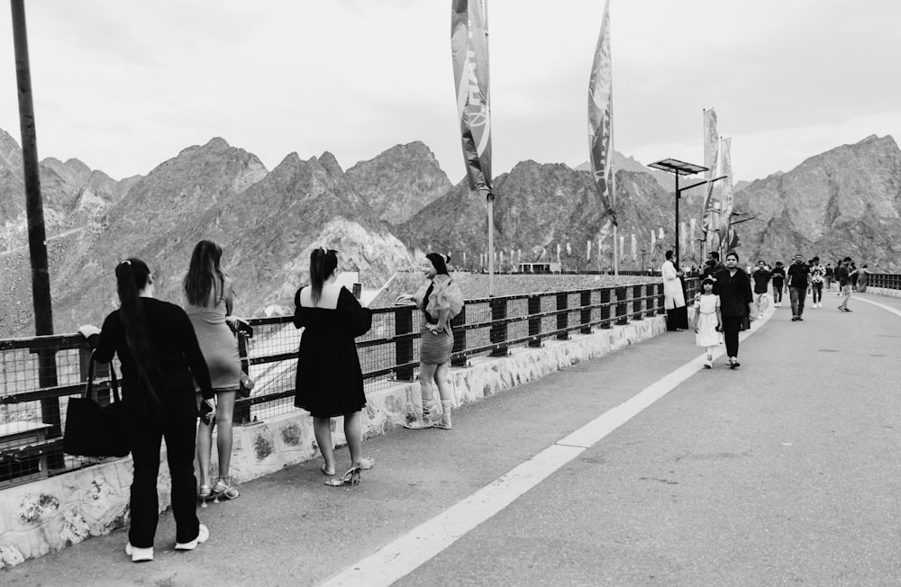 a group of people standing on the side of a road