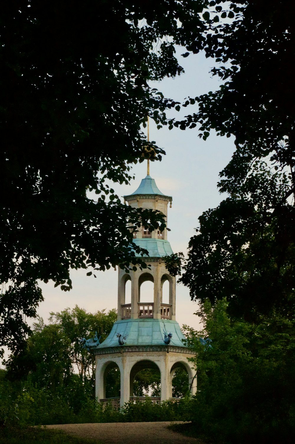 a white and blue clock tower surrounded by trees