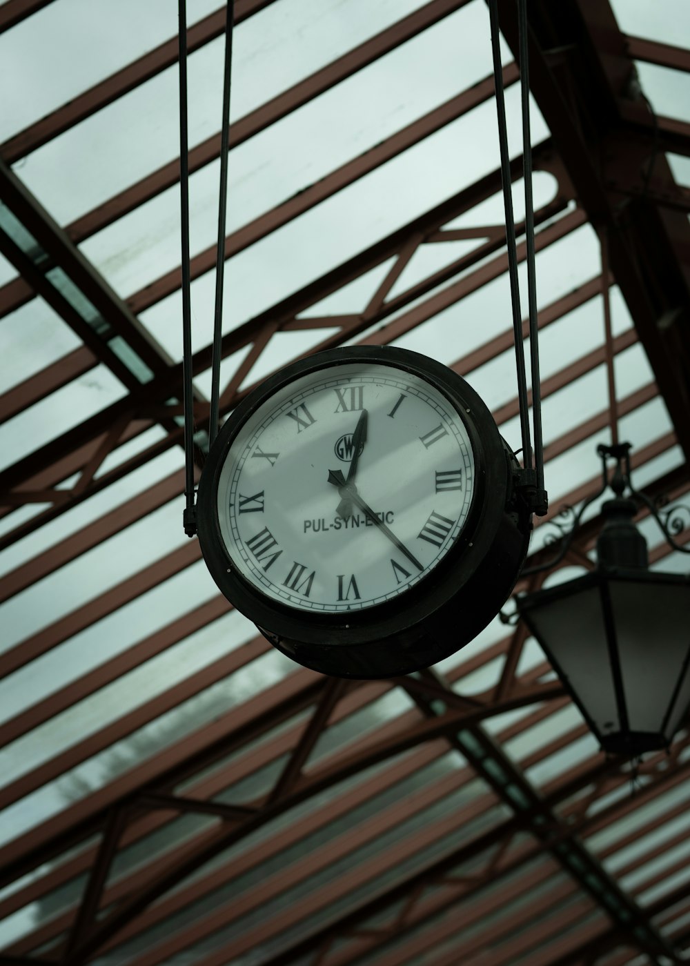 a clock hanging from the ceiling of a building