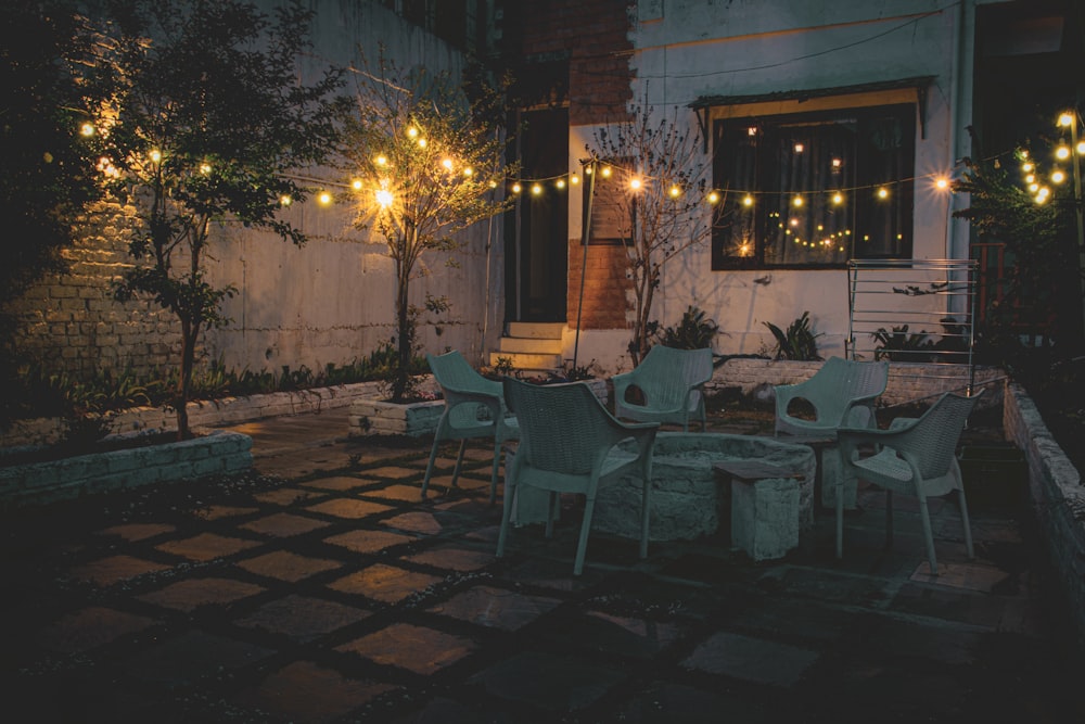 a patio with a table, chairs and lights