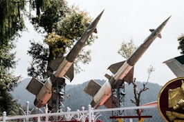 a row of military missiles on display behind a fence