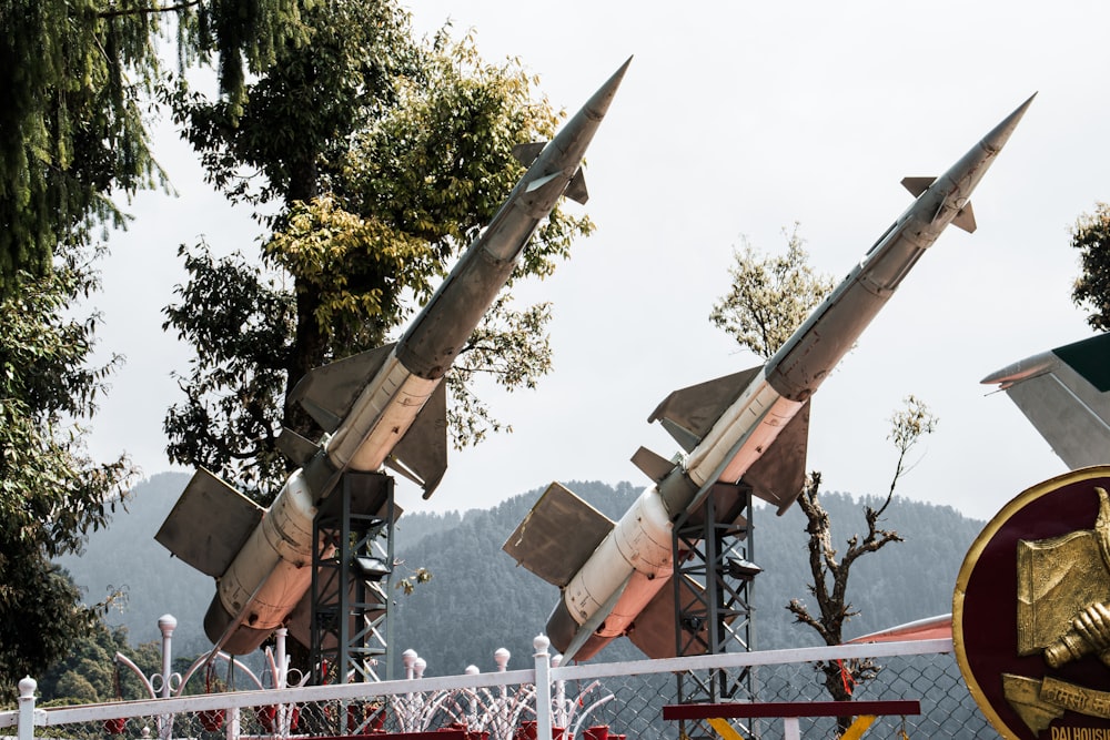 a row of military missiles on display behind a fence