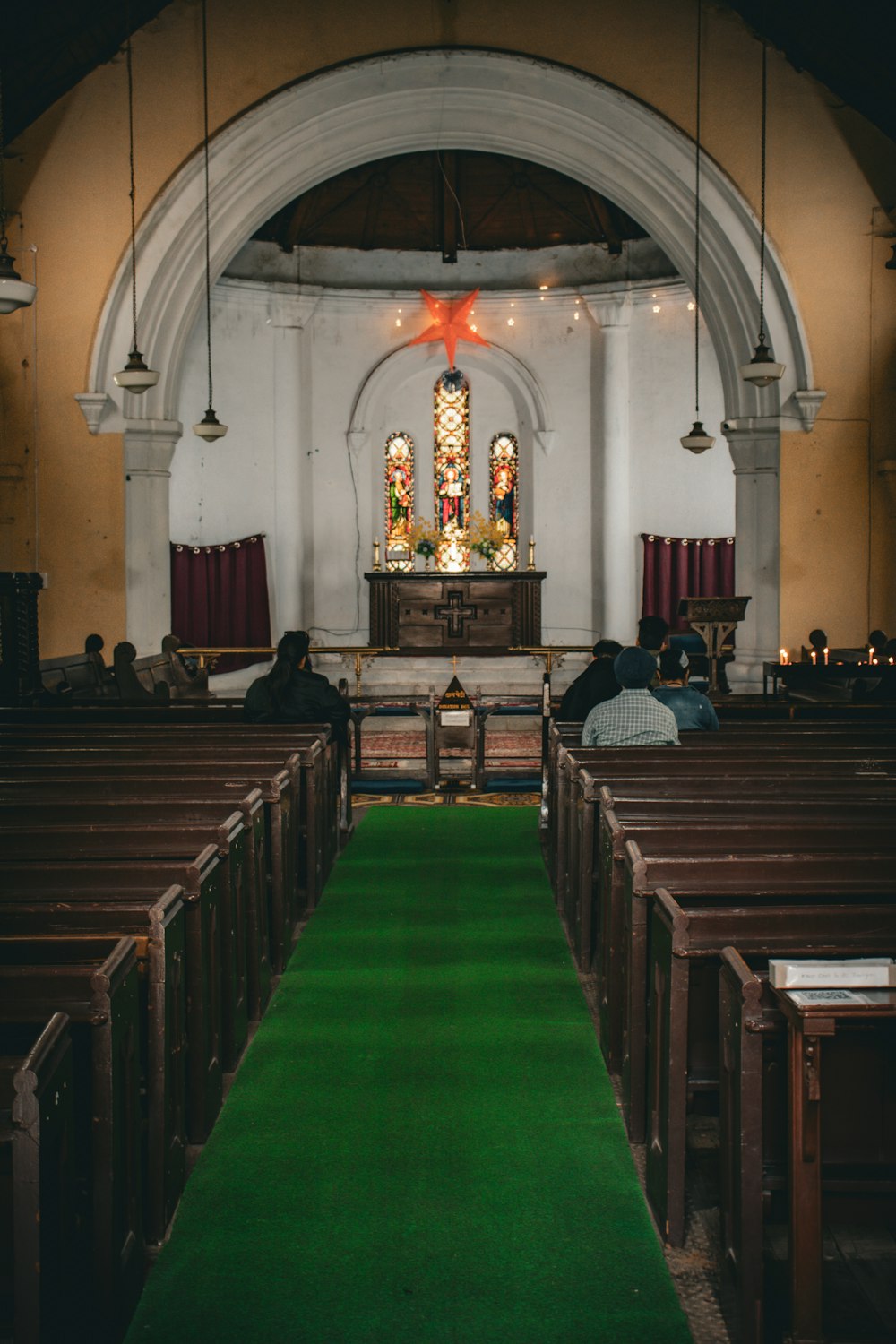 a church filled with pews and a green carpet