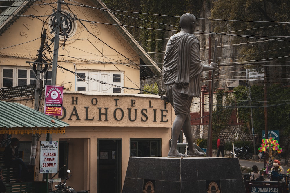 a statue of a man standing in front of a hotel