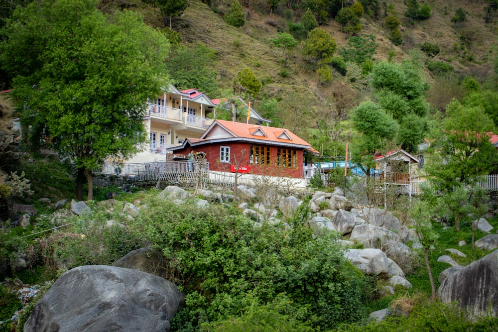 a red house sitting on top of a lush green hillside