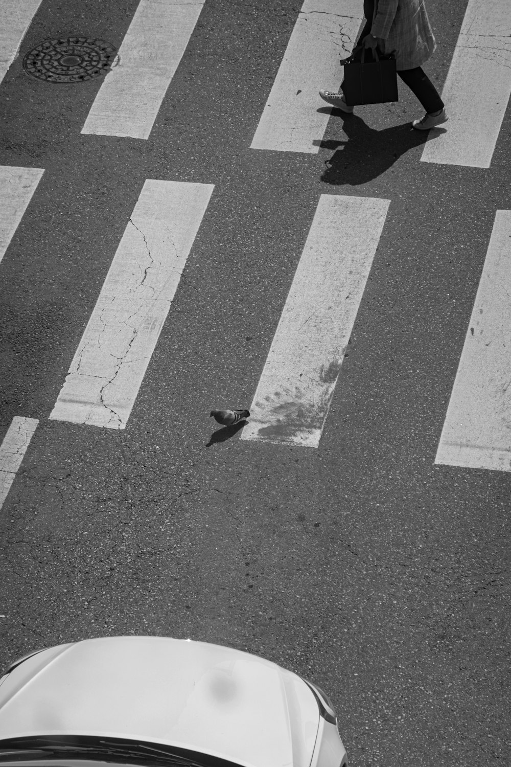 a black and white photo of a person crossing a street