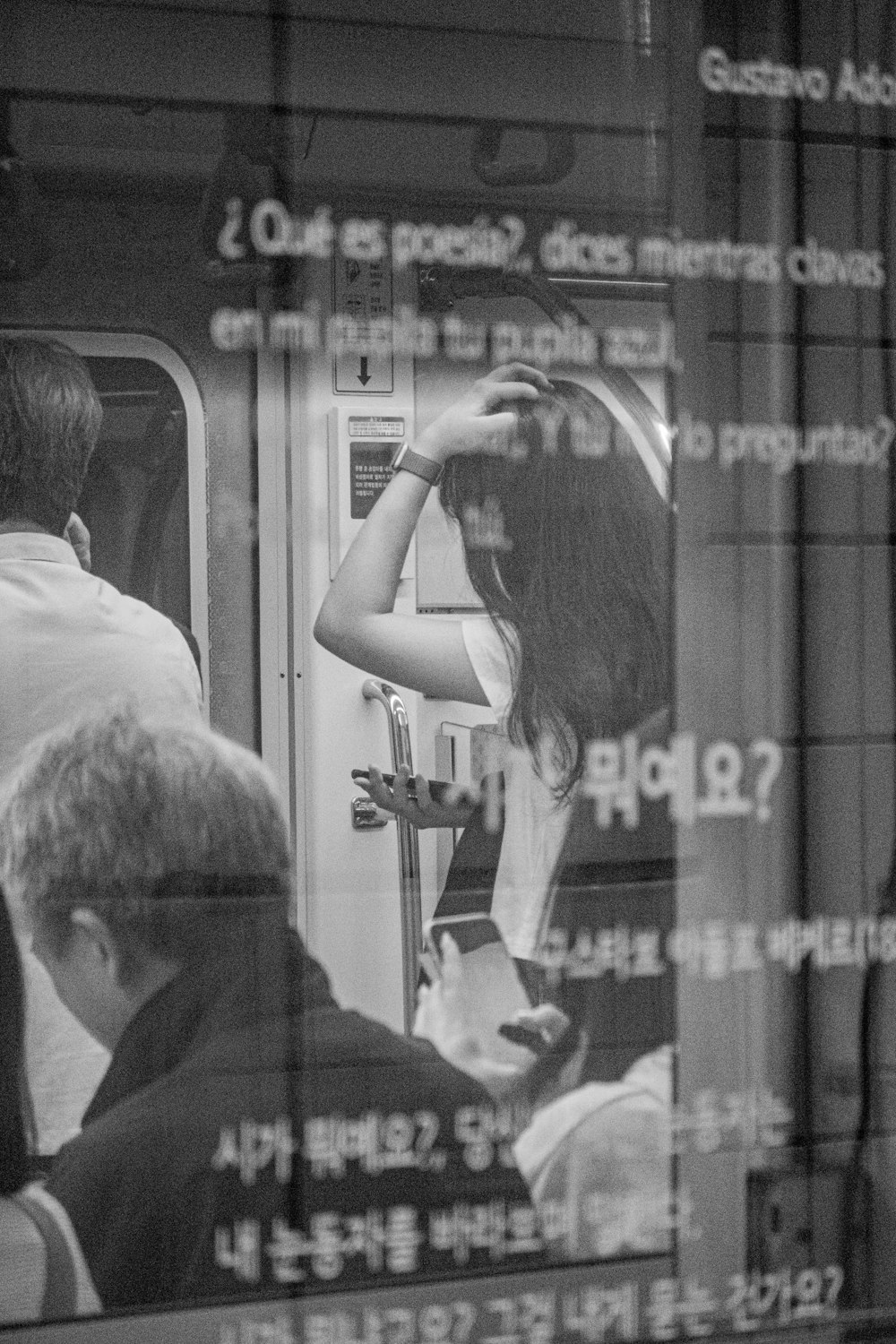 a black and white photo of a woman on a train